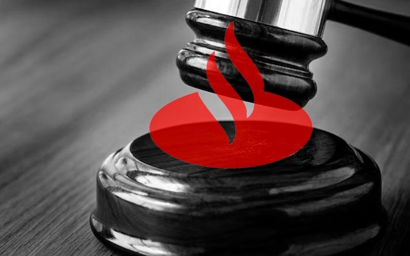 Arte composta por uma imagem de um malhete sobreposta ao logo do Santander