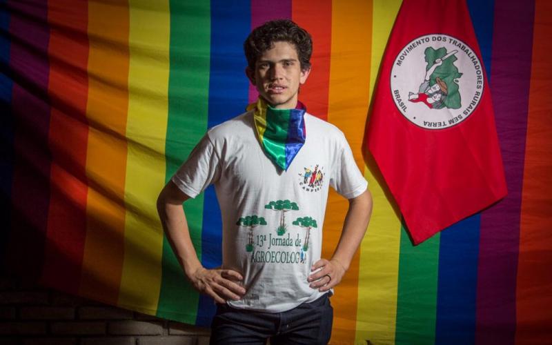 Foto: Rafael Stedile/MST Foto do militante Lindolfo Kamaski com as bandeiras LGBT e do MST ao fundo