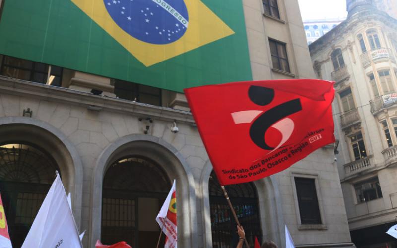 Manifestantes protestam em frente à Bolsa de Valores de São Paulo (B3), ironicamente ornamentada com a bandeira do Brasil, mas palco da entrega do patrimônio nacional Foto: Seeb-SP