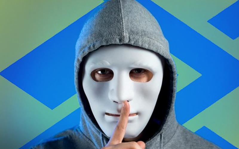 Arte composta por um homem vestindo capuz e máscara na cor branca cobrindo todo o rosto, fazendo sinal de silêncio com o dedo indicador em riste diante da boca. Ao fundo, o logo do Banco do Brasil