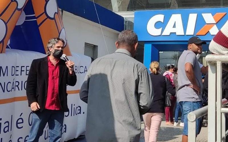 O dirigente sindical e empregado da Caixa Danilo Perez durante protesto contra assédio moral em frente a agência da Caixa Econômica Federal em Guianazes O dirigente sindical e empregado da Caixa Danilo Perez durante protesto contra assédio moral em frente a agência da Caixa Econômica Federal em Guianazes