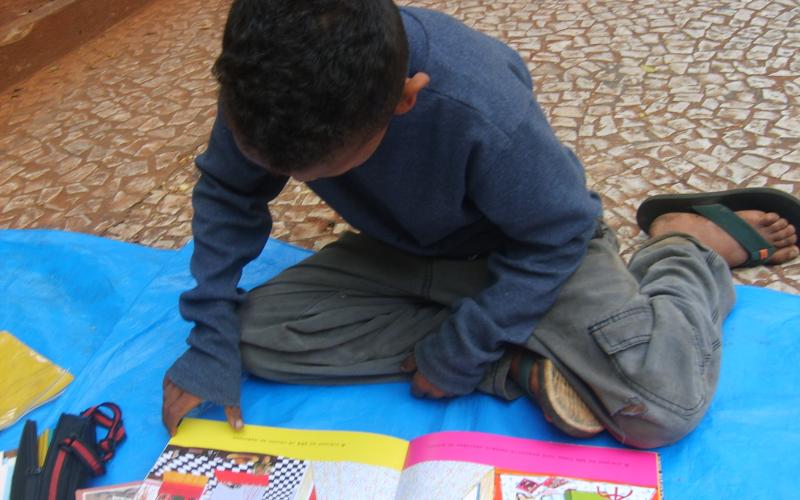 Criança lê em atividade lúdica desenvolvida por educadores da Fundação Travessia. Contribua para a continuidade desse projeto: doe pelo Catarse Foto: Fundação Projeto Travessia