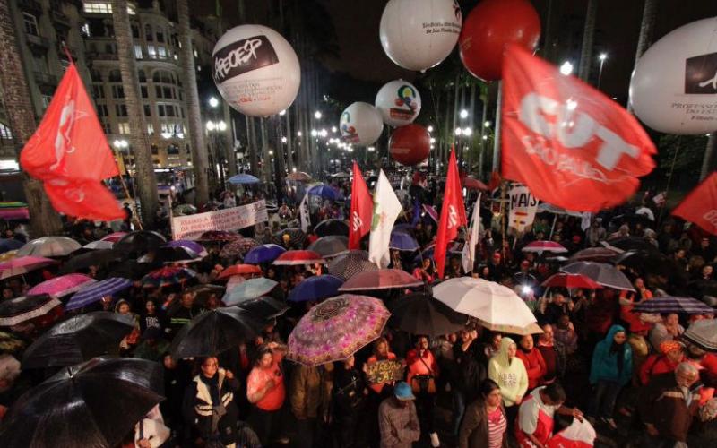 Ato na Praça da Sé começou com chuva por volta das 17h: manifestantes se aglomeraram próximos ao carro de som Foto: CUT/SP