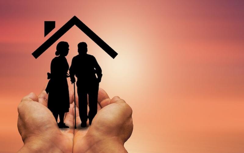 Geralt/Pixabay Imagem de uma mão amparando um casal de idosos sob um telhado de uma casa