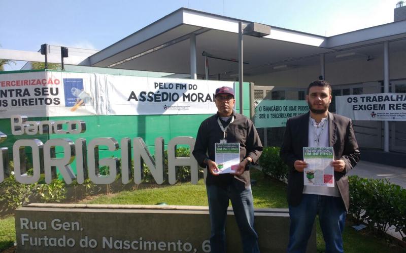 Dirigentes sindicais Amauri Silva e Rodrigo Pires seguram panfleto denunciando abusos distribuído durante o protesto Foto: Seeb-SP
