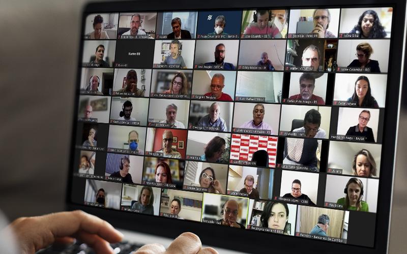 Arte com foto da tela de computador na qual são exibidos os rostos dos membros do Comando Nacional dos Bancários e da Fenaban que participaram de reunião