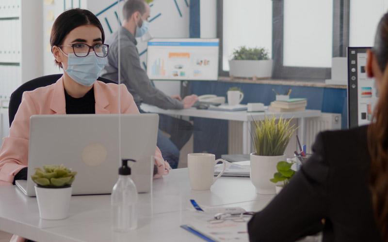 Imagem: Freepik Fotografia de bancários de máscaras no local de trabalho