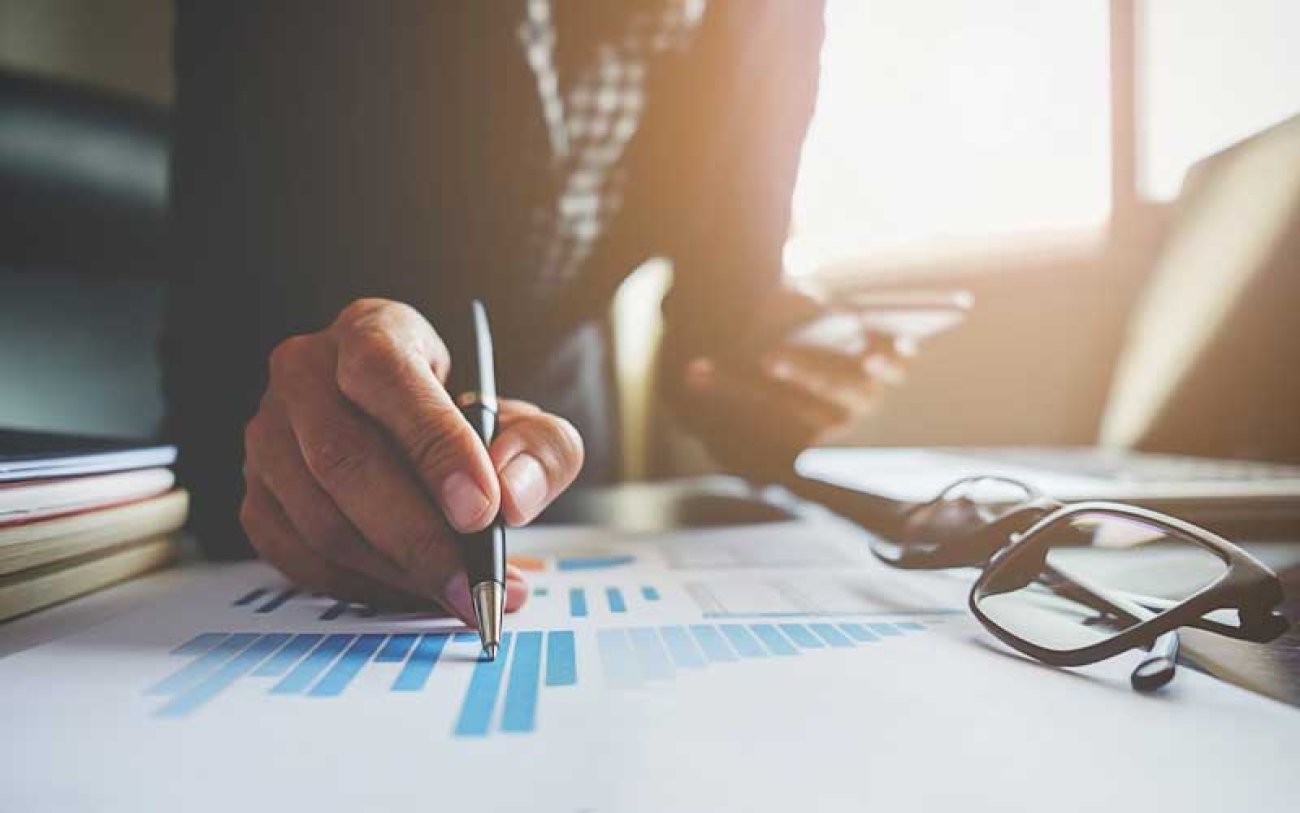 Imagem: Freepik Imagem de um bancário acompanhando seus investimentos