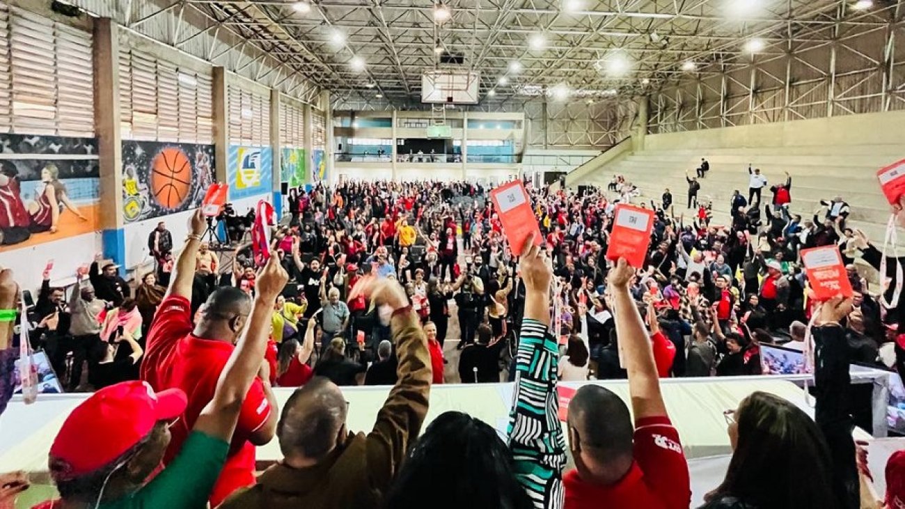 Trabalhadores de diversos ramos cutistas erguem crachás para eleger a nova direção da CUT-SP para o quadriênio 2023-2027. Foto: Seeb-SP Imagem mostra trabalhadores de diversos ramos cutistas erguendo crachás para eleger a nova direção da CUT-SP para o quadriênio 2023-2027