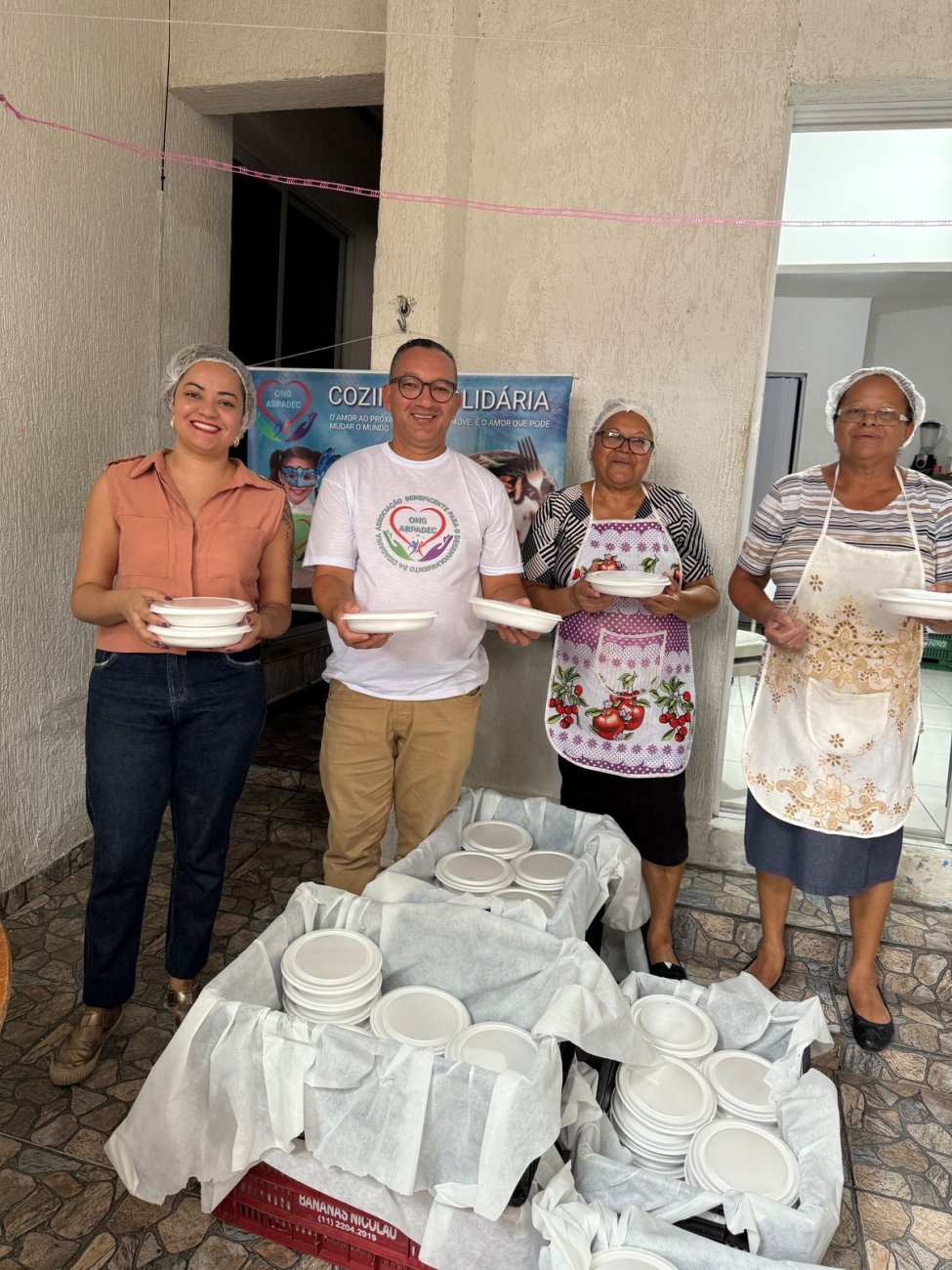 Fotografia mostrar pessoas com tocas higiênicas e marmitas nas mãos para distribuir nas ruas de São Paulo