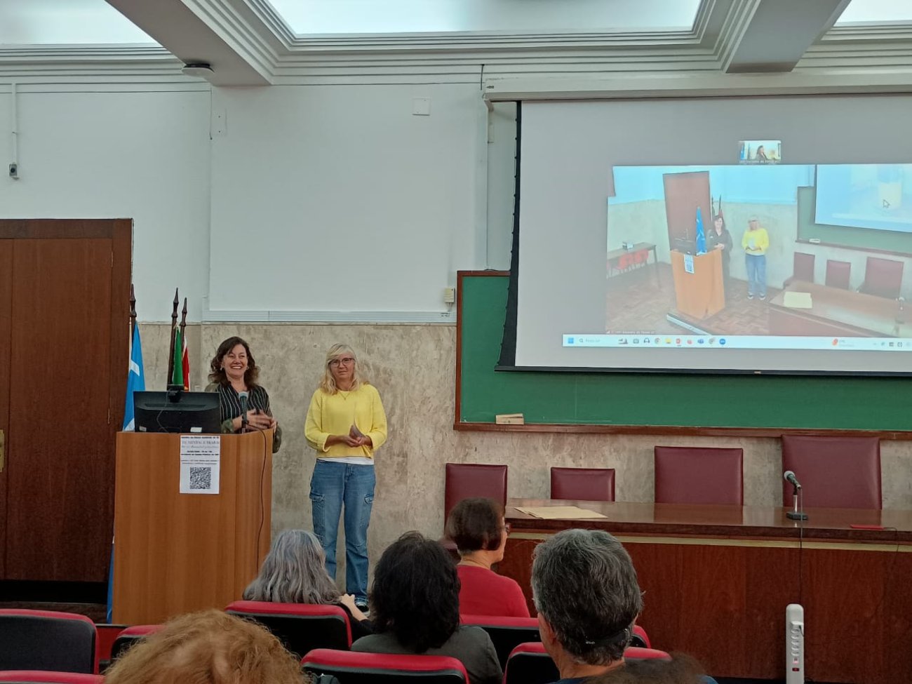 Sindicato participa de Fórum Acidente de Trabalho na USP Fotografia mostra duas mulheres em pé. Valeska Pincovai, secretária de saúde do Sindicato usa blusa amarela e calça jeans