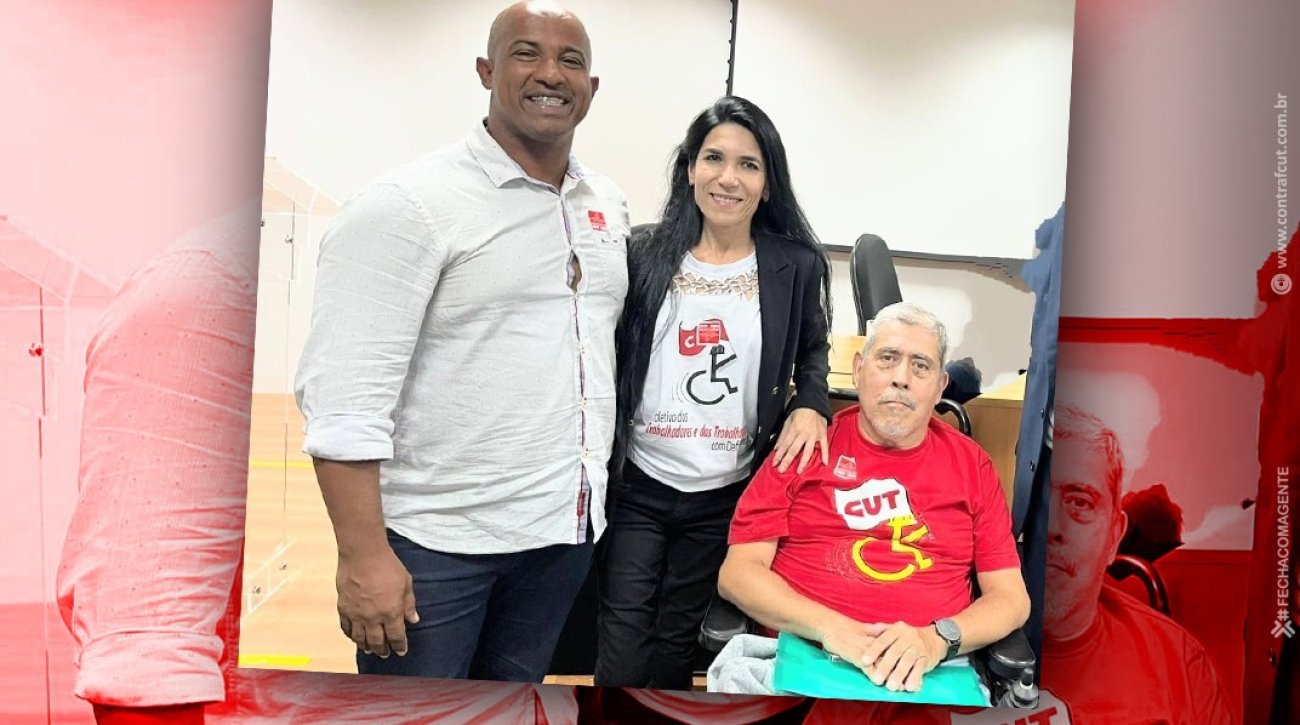 Bancários participam de eleição do Conade, em Brasília Fotografia mostra integrantes do Conade: Um homem negro camisa branca, mulher ao meio de cabelos pretos e um homem sentado na cadeira de rodas