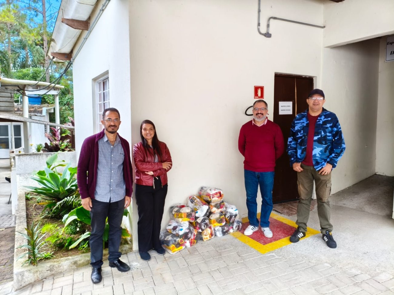 Sindicato faz entrega das doações dos bancários da Regional Alphaville a sete instituições Fotografia mostra pessoas em pé ao lado de cestas básicas que serão doadas