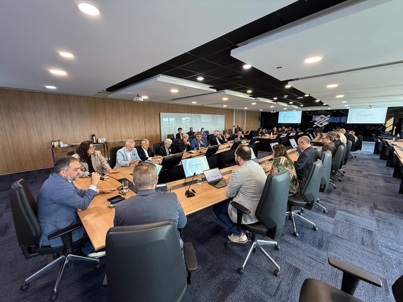 Imagem da reunião entre o Sindicato e a direção do Banco do Brasil. A foto mostra uma sala onde estão reunidos, em uma mesa comprida representantes do sindicato e dirigentes do banco do brasil