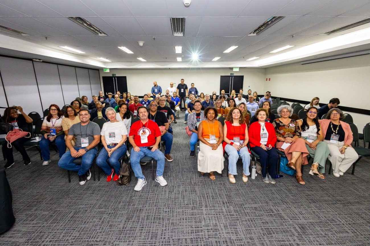 Imagem mostra dirigentes sindicais sentados em plenário lotado durante encontro nacional do Santander