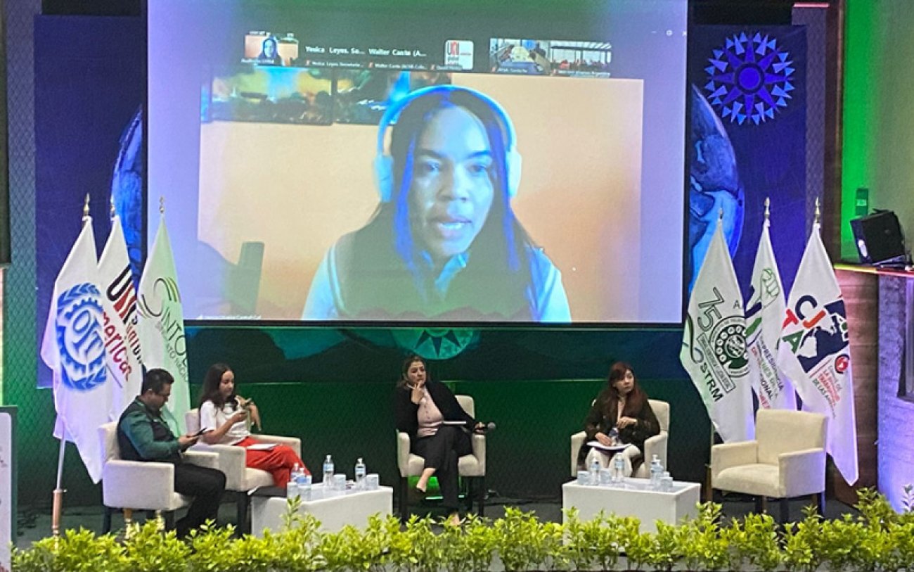 No telão, Mércia Oliveira, participa representando os bancários de São Paulo na UNI Fotografia mostra participantes no debate no México e Mércia no telão do Brasil