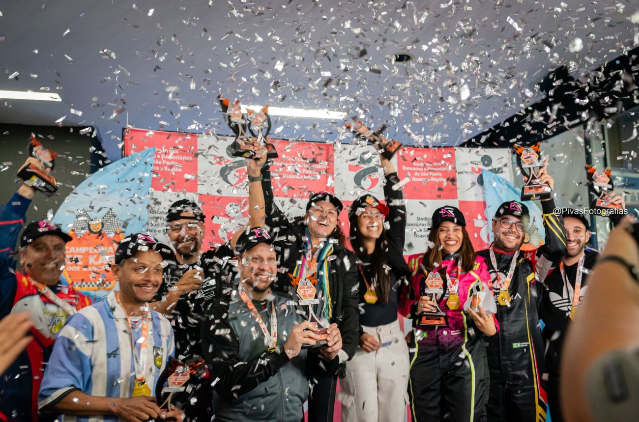 Ganhadores do 3º Torneio de Kart dos Bancários Foto: Seeb-SP Fotografia mostra corredores do Kart com troféus nas mãos em chuva de confete