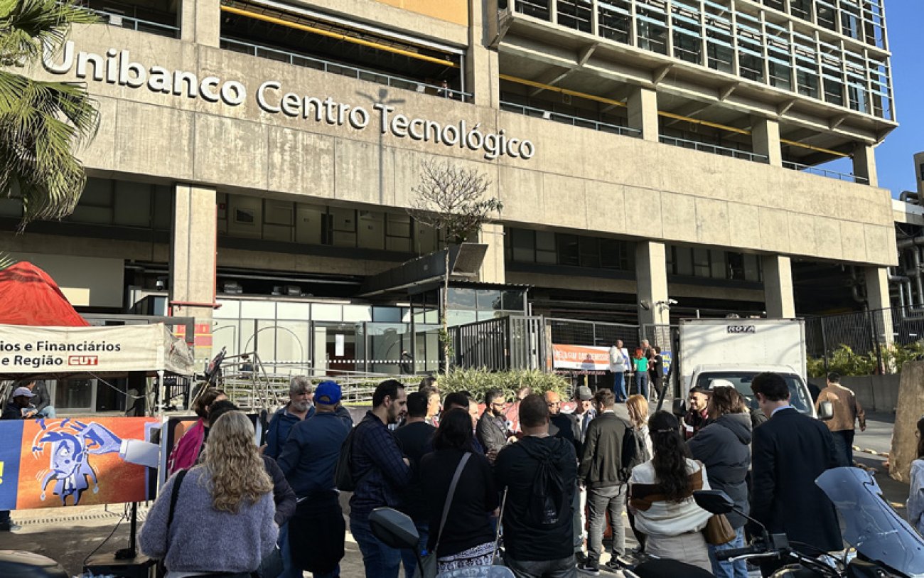 Foto da fachada do Centro Tecnológico do Itaú, onde se vê faixa do Sindicato e vários bancários na porta do prédio que foi paralisado pelo Sindicato
