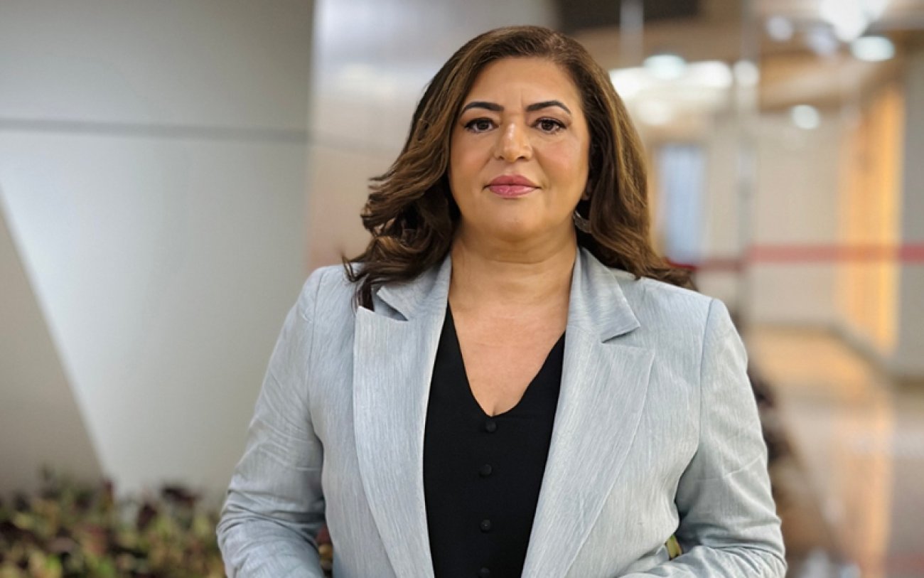 Imagem mostra Neiva Ribeiro, presidenta do Sindicato dos Bancários de São Paulo. É uma mulher morena com cabelos escuros e lisos. Veste um terno cinza claro sobre uma blusa preta