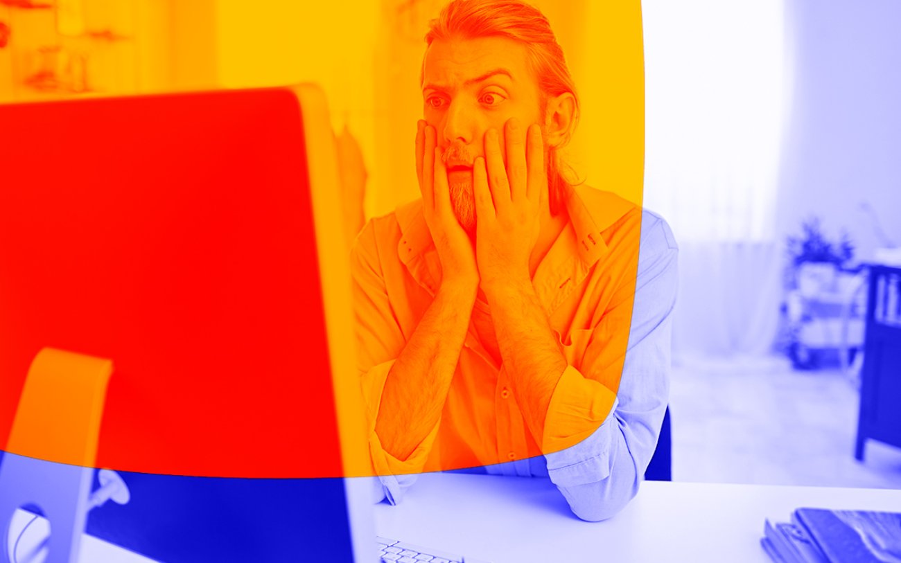 Imagem de um homem chocado olhando para a tele do computados (Imagem: Freepik)