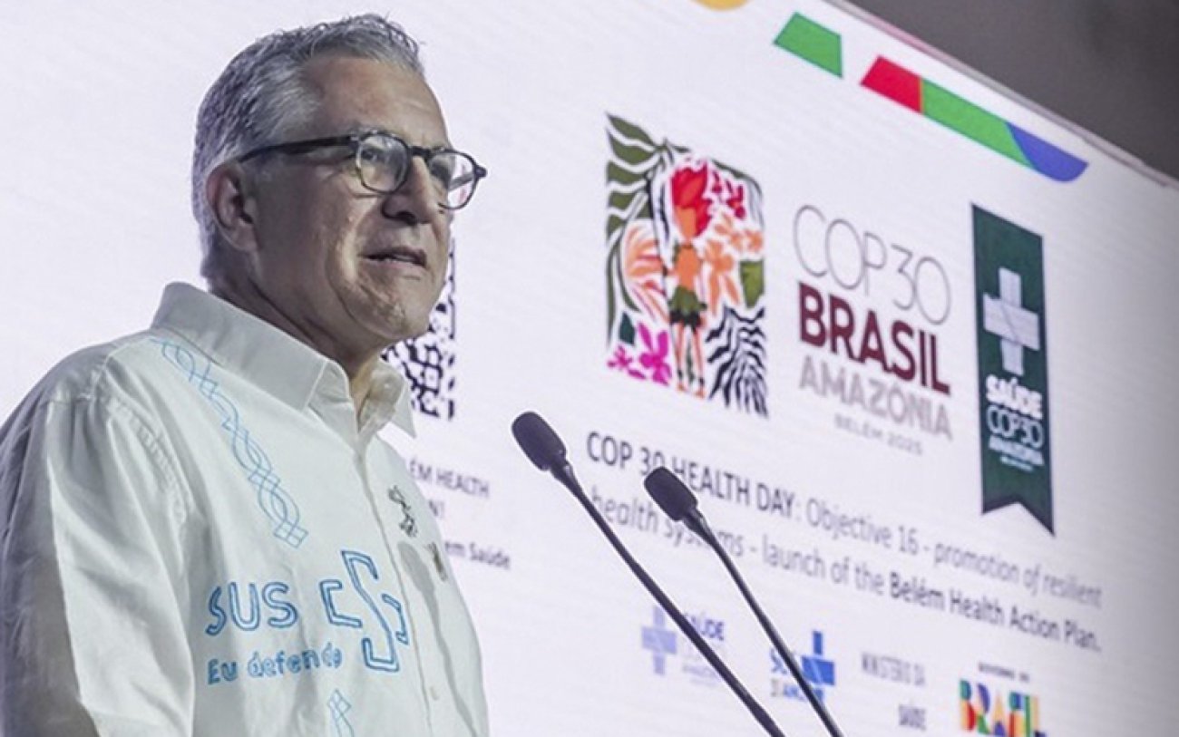 Homem branco com camisa branca falando ao microfone