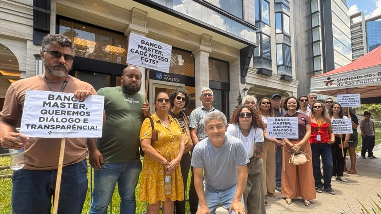 Imagem mostra dirigentes do sindicato perfilados em frente ao prédio da sede do banco master