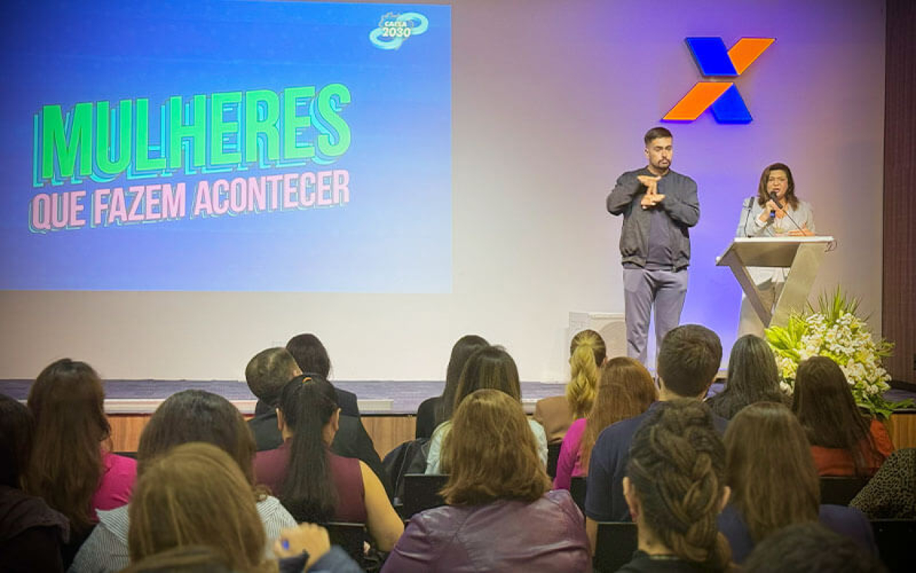 Foto de Neiva Ribeiro no palco do evento "Mulheres que fazem acontecer", promovido pela Caixa