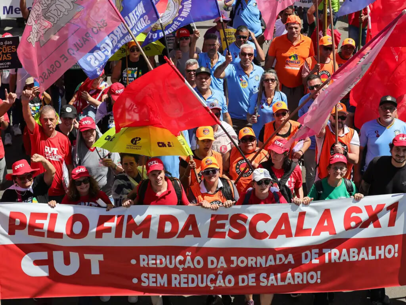 Foto da Marcha da Classe Trabalhadora, em abril de 2026; na foto os manifestantes seguram uma grande faixa assinada pela CUT  onde se lê: Pelo Fim da Escala 6x1