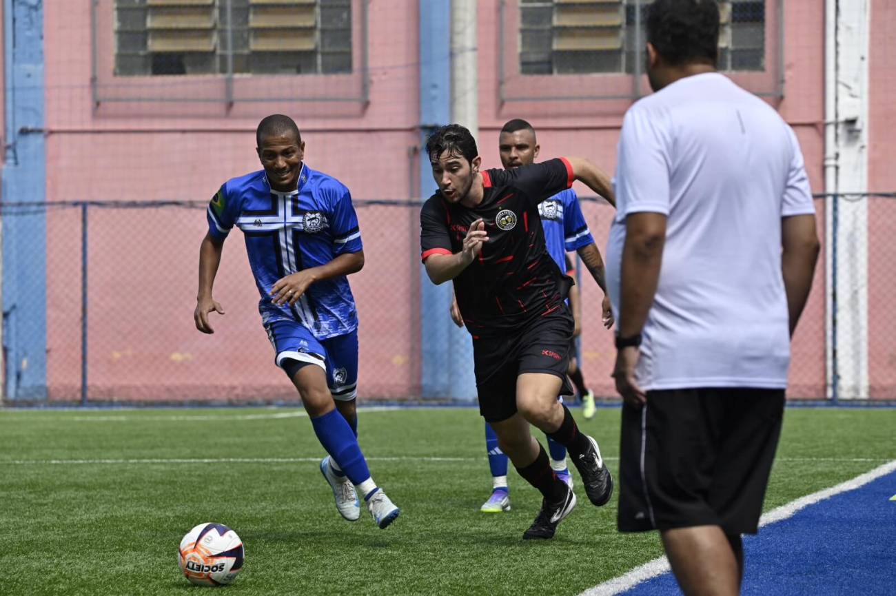 Jogador de futebol disputando a bola com adversários