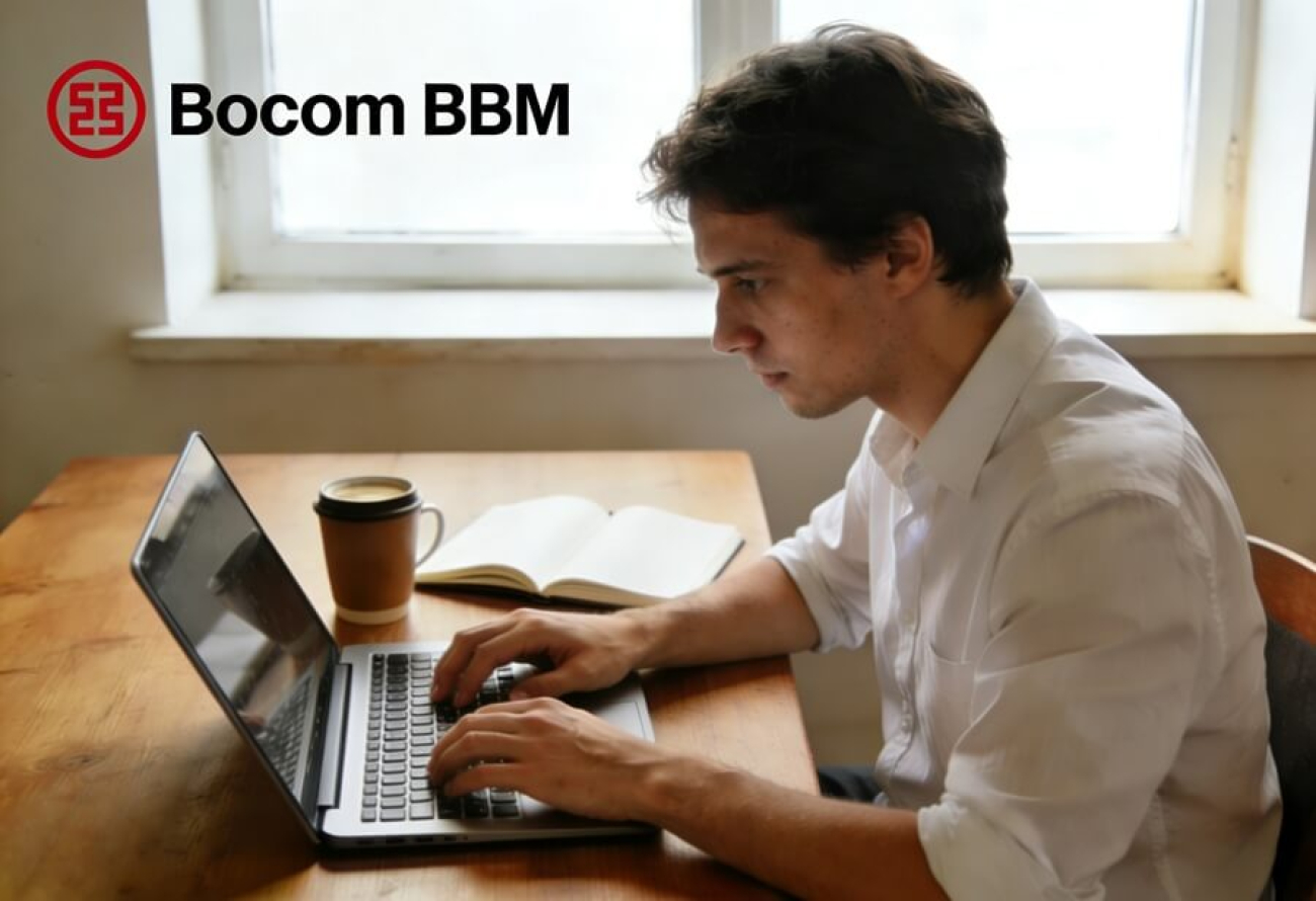 Imagem mostra um homem jovem, branco e de cabelos curtos trabalhando em um computador