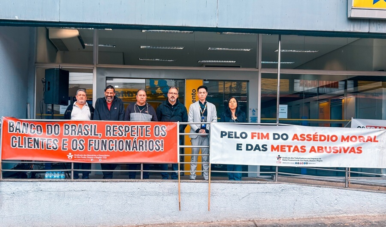 imagem mostra dirigentes perfilados em frente a uma agência do banco do brasil