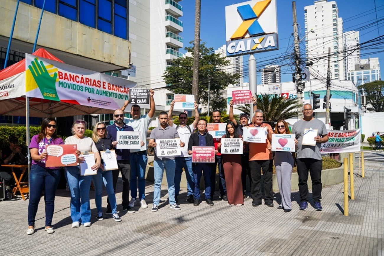 Imagem mostra trabalhadores protestando em frente a uma agência da Caixa