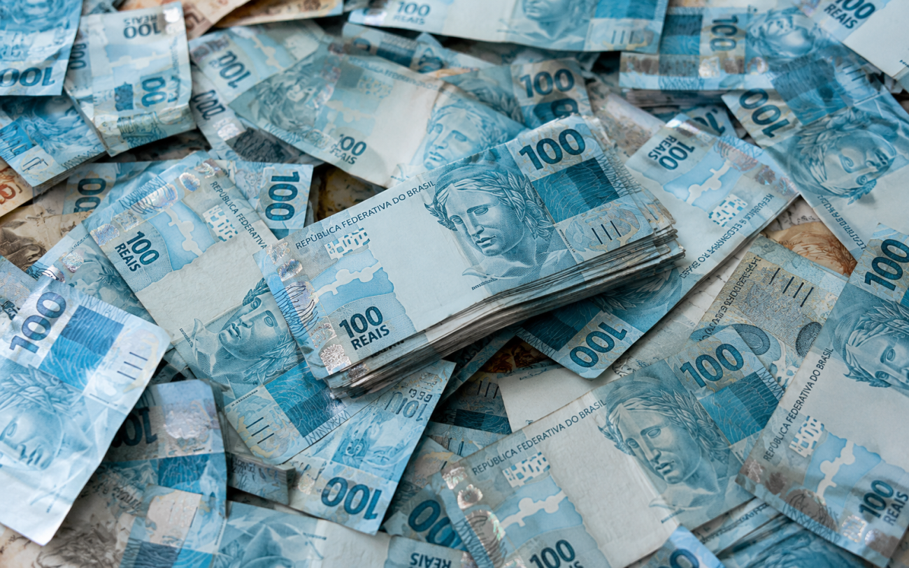 Imagem de diversas notas de R$ 100 sobrepostas