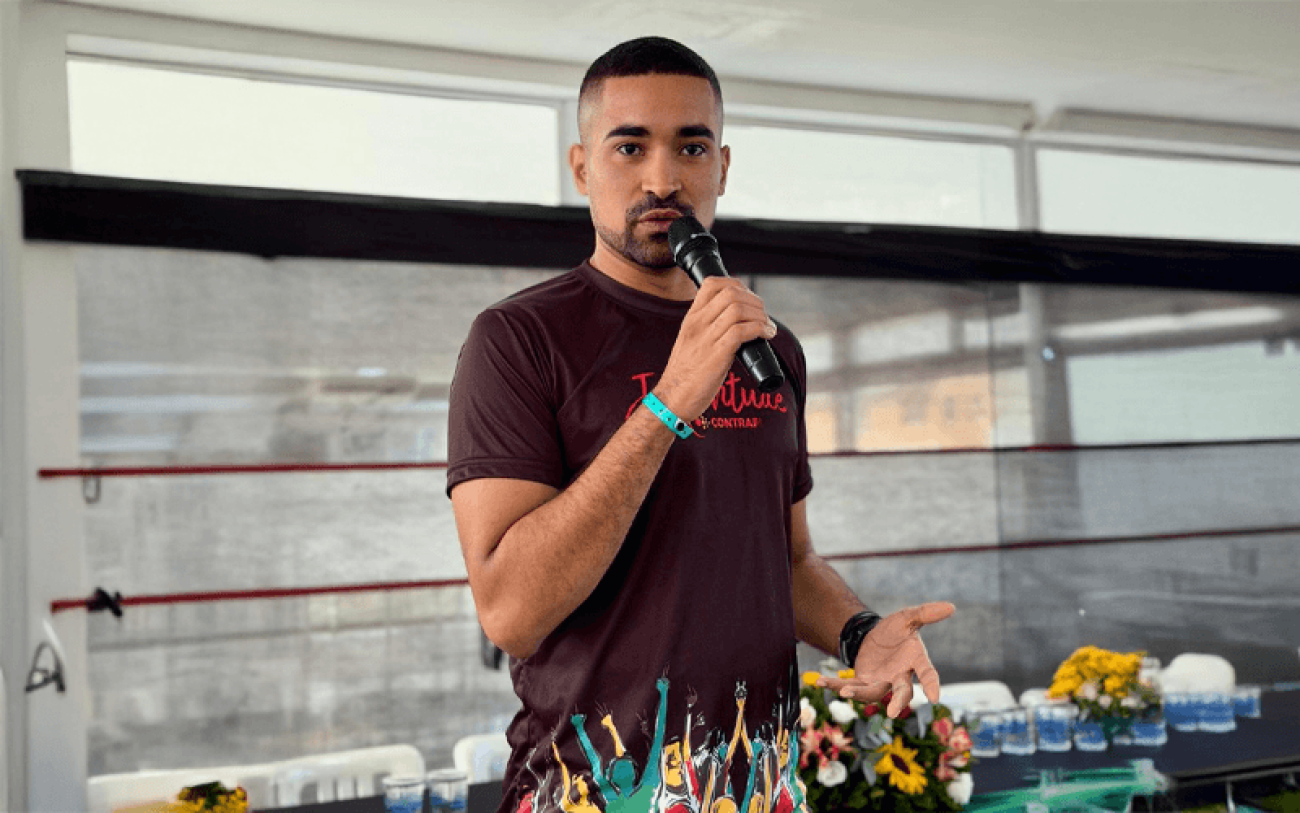 Foto de Matheus Pinho falando ao microfone