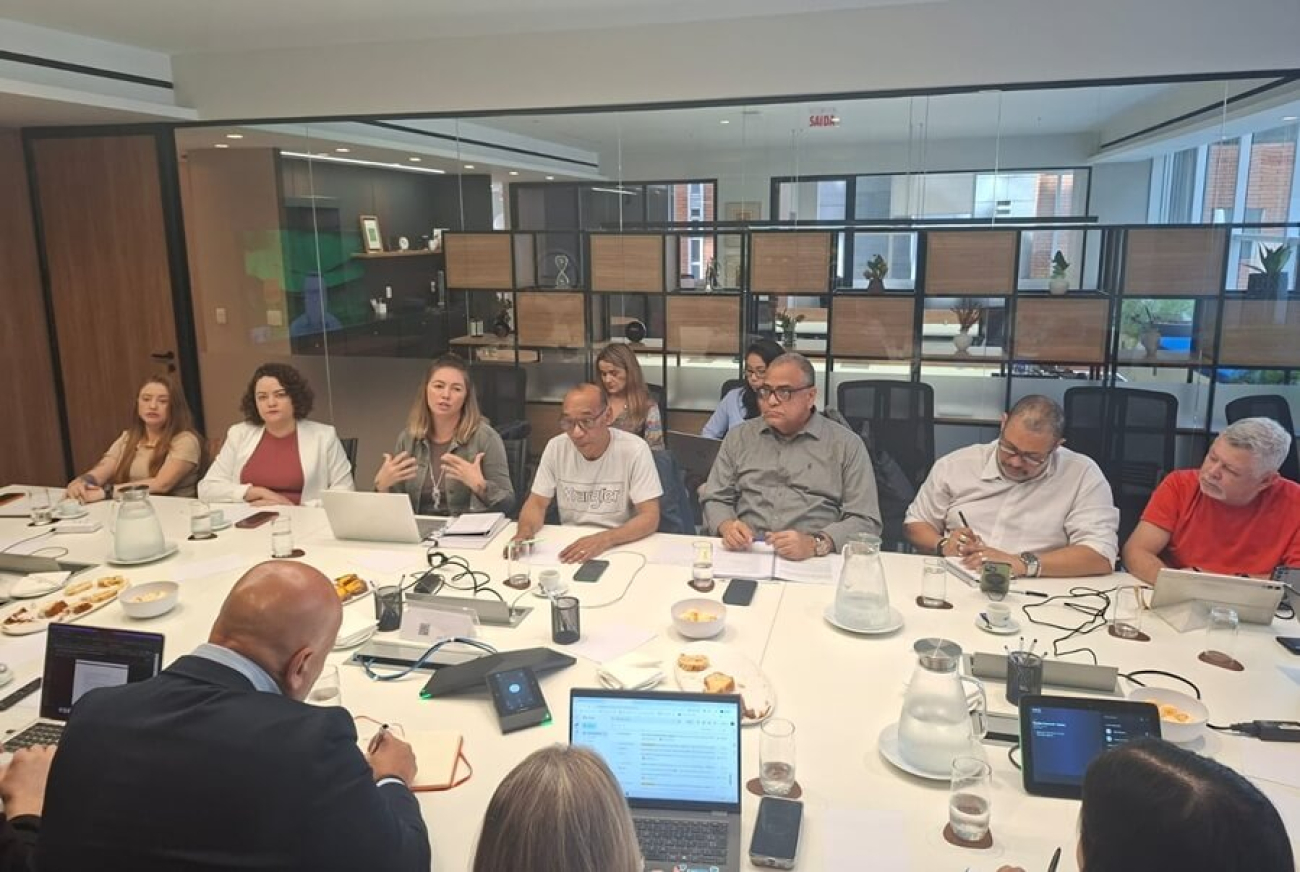 Imagem mostra representantes das financeiras e dos trabalhadores reunidos em torno de uma mesa