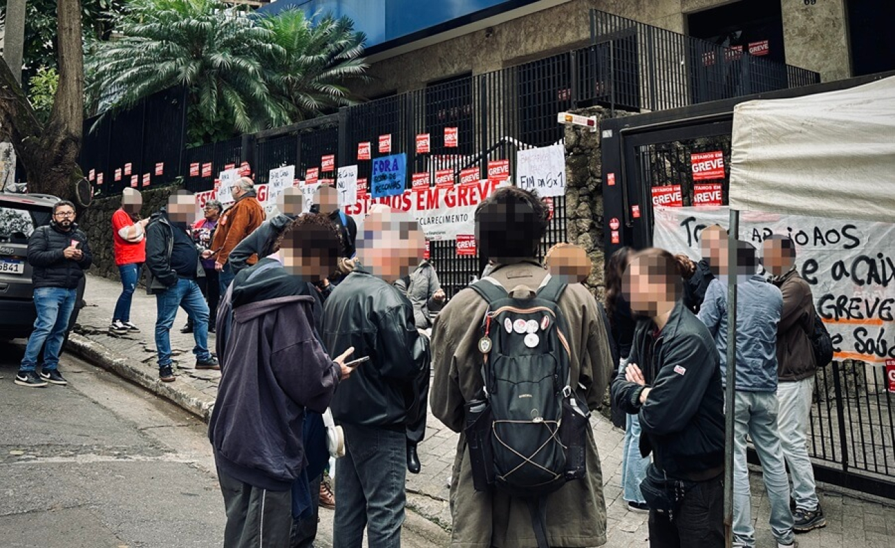 Imagem mostra empregados da Caixa Econômica Federal em frente ao prédio paralisado da Caixa na Liberdade (prédio da São Joaquim)