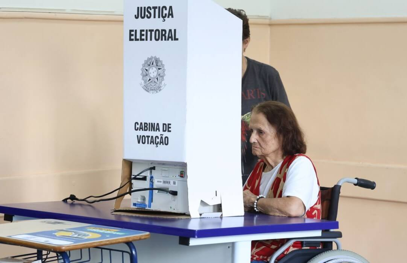 Senhora, em uma cadeira de rodas, votando