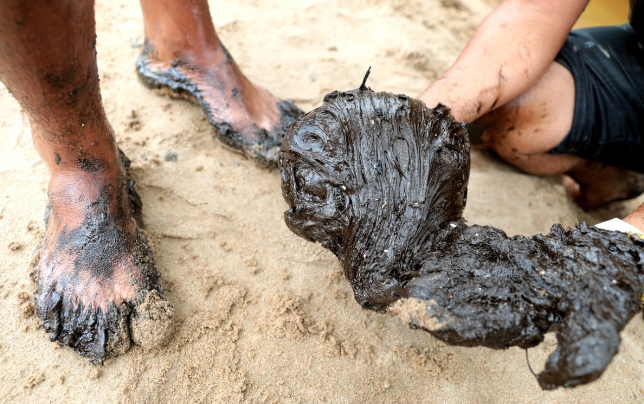 Voluntários tiveram problemas de pele e reações como dor de cabeça e enjoos por contato e inalação dos gases que saem das manchas Foto: ARNALDO CARVALHO/JC IMAGEM/FOLHAPRESS