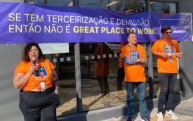 Dirigentes perfilados em frente a uma agência do Itaú em cuja fachada está exposta uma faixa onde se lê: "se tem terceirização e demissão, não é um 'Great Place to Work'"