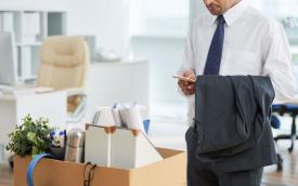 Imagem mostra um trabalhador recolhendo seus pertences no escritório