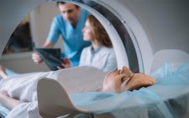 Imagem mostra uma mulher passando por uma ressonância magnética