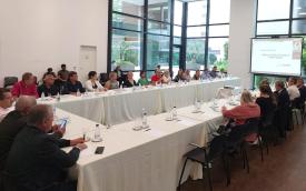 Imagem mostra dirigentes sindicais e representantes da Fenaban sentados em uma mesa comprida em formato de "U", com uma toalha branca. Diante deles, um telão apresenta os números da pesquisa