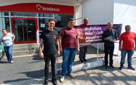 Fotografia mostra bancários em frente a uma agência do Bradesco em Osasco