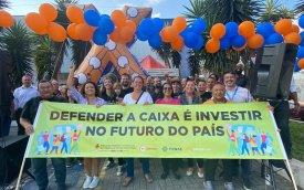 Imagem mostra bancários atrás de uma faixa onde se lê  'Defender a Caixa é investir no futuro do país'