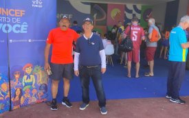 Fotografia mostra dois homens com roupas esportivas nas cores vermelho, azul e branco 