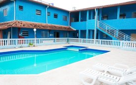 fotografia mostra fachada de pousada com as cores azul, branco e verde claro