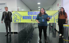 Fotografia mostra tres pessoas segurando faixa pedindo respeito ao Banco do Brasil