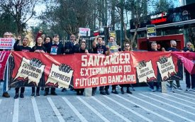 Imagem  mostra dirigentes sindicais em frente ao prédio da Torre Santander portando uma faixa onde se lê "Santander, o exterminador de empregos"