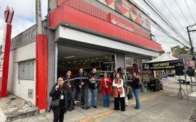 Imagem mostra dirigentes sindicais em frente a uma agência do santander, durante protesto contra o fechamento da unidade, os dirigentes estão de braços cruzados e lado a lado