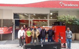 Imagem mostra dirigentes sindicais enfileirado em frente a uma agência do Bradesco. na frente deles, um caixão representando a morte dos empregos bancários e das agências